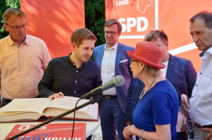 Kevin Kühnert unterhält sich mit Brigitta Stöber beim Eintrag in das goldene Buch der Stadt